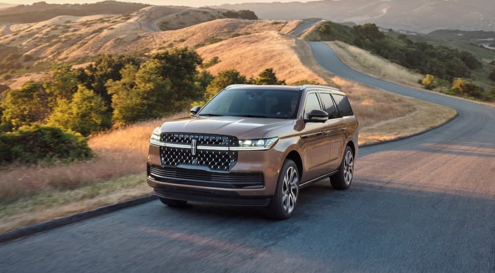 A tan 2026 Lincoln Navigator driving on a highway.