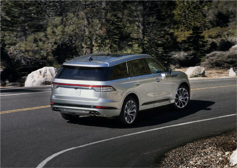 A 2023 Lincoln Aviator® Grand Touring model is shown being driven on a tight turn of a mountain road | LaFontaine Lincoln Grand Blanc in Flint MI