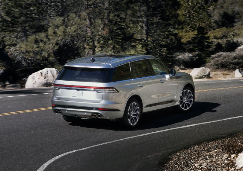 A 2023 Lincoln Aviator® Grand Touring model is shown being driven on a tight turn of a mountain road | LaFontaine Lincoln Flushing in Flushing MI