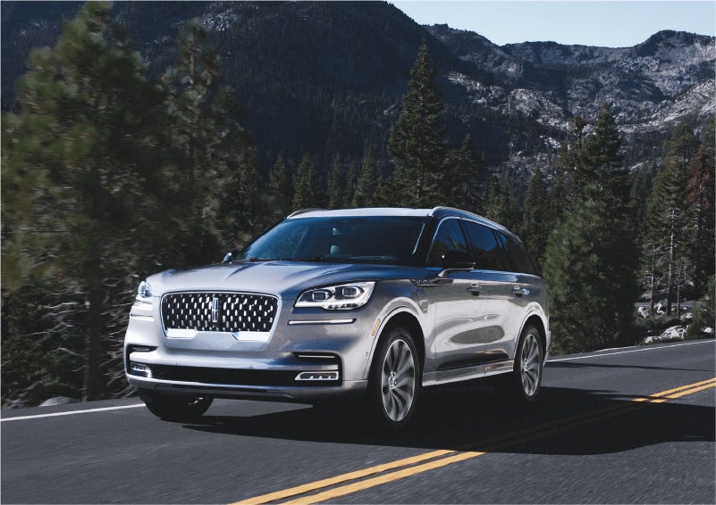 A 2023 Lincoln Aviator® Grand Touring SUV being driven on a winding road to demonstrate the capabilities of all-wheel drive | LaFontaine Lincoln Flushing in Flushing MI