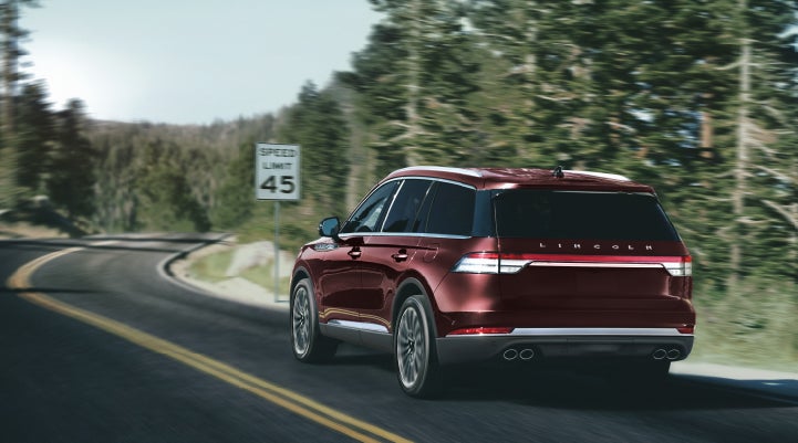 A 2024 Lincoln Aviator® SUV is being driven on a winding mountain road | LaFontaine Lincoln Flushing in Flushing MI