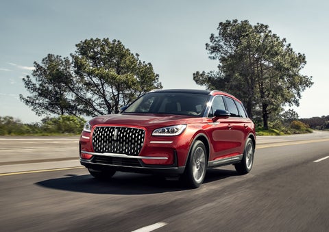 A 2024 Lincoln Corsair® SUV is shown being driven on a country road. | LaFontaine Lincoln Grand Blanc in Flint MI