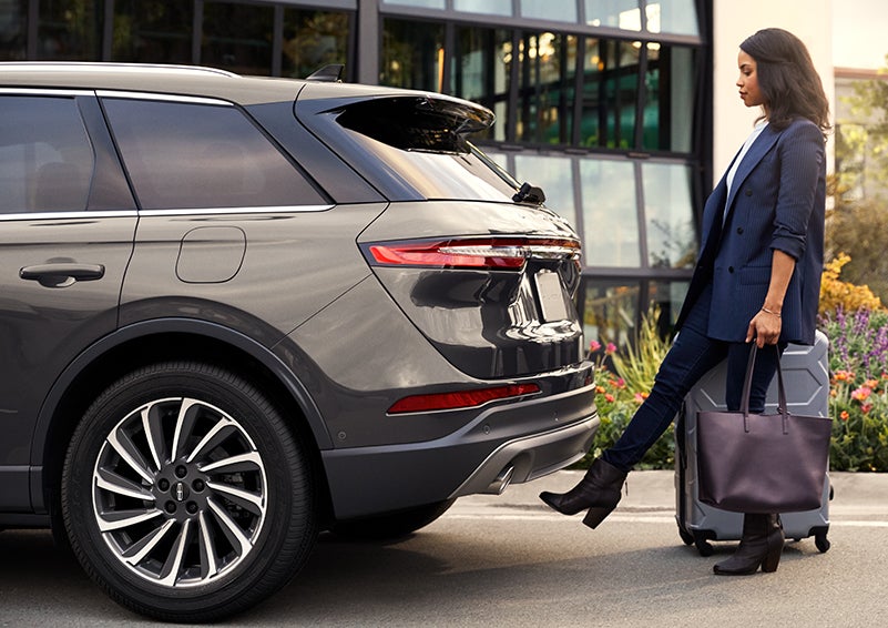 A woman with her hands full uses her foot to activate the available hands-free liftgate. | LaFontaine Lincoln Grand Blanc in Flint MI