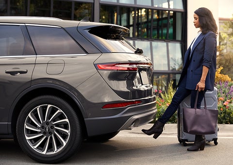 A woman with her hands full uses her foot to activate the available hands-free liftgate. | LaFontaine Lincoln Grand Blanc in Flint MI