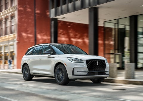 The 2024 Lincoln Corsair® SUV with the Jet Appearance Package and a Pristine White exterior is parked on a city street. | LaFontaine Lincoln Grand Blanc in Flint MI
