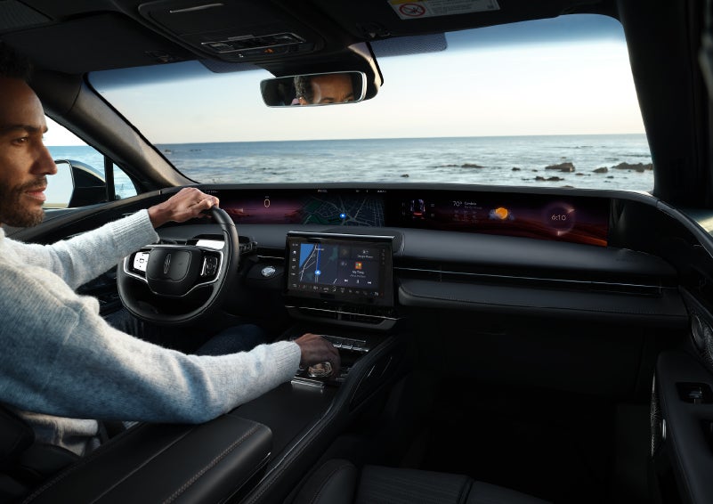 A driver of a parked 2024 Lincoln Nautilus® SUV takes a relaxing moment at a seaside overlook while inside his Nautilus. | LaFontaine Lincoln Flushing in Flushing MI