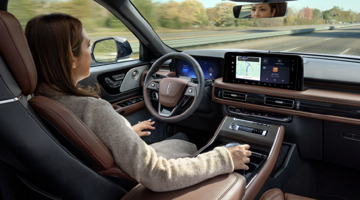 A woman is seen sitting in the driver’s seat of her 2025 Lincoln Aviator® SUV with her hands off the steering wheel. | LaFontaine Lincoln Grand Blanc in Flint MI