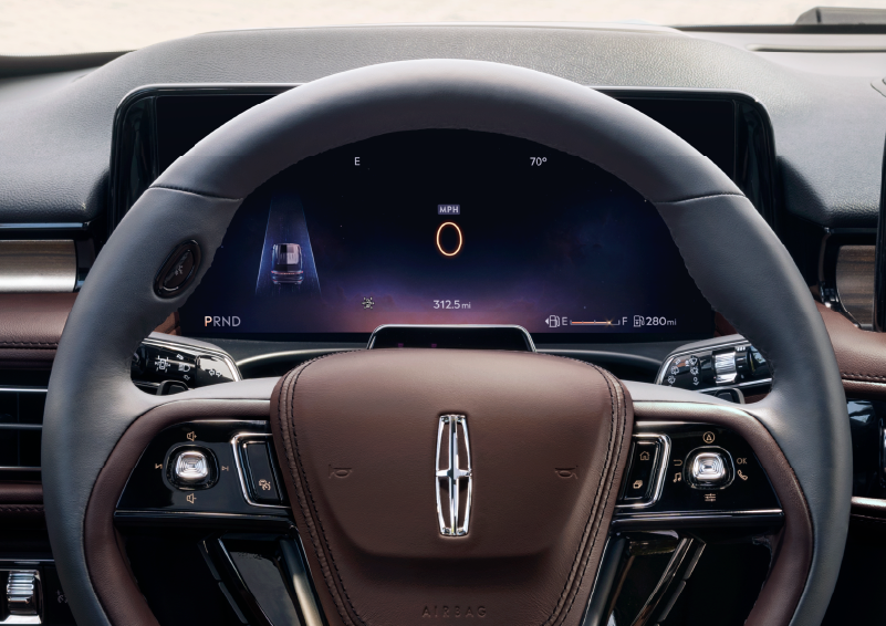 The steering wheel of 2025 Lincoln Aviator® SUV is shown with black and brown accents. | LaFontaine Lincoln Grand Blanc in Flint MI