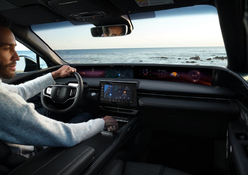 A driver of a parked 2025 Lincoln Nautilus® SUV takes a relaxing moment at a seaside overlook while inside his Nautilus. | LaFontaine Lincoln Grand Blanc in Flint MI