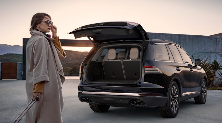 A woman approaches a 2026 Lincoln Aviator® SUV with its rear liftgate open. | LaFontaine Lincoln Grand Blanc in Flint MI