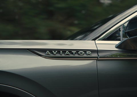 The driver’s side door and fender badging of a gray 2027 Lincoln Aviator® SUV are showcased. | LaFontaine Lincoln Grand Blanc in Flint MI