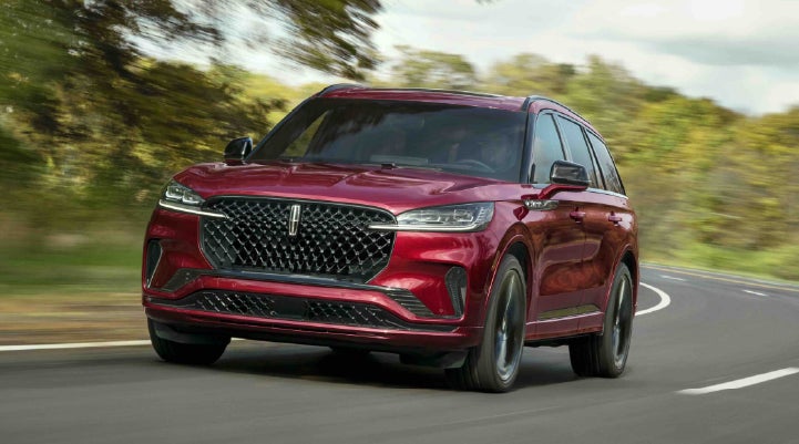 A 2027 Lincoln Aviator® SUV is being driven on a country road | LaFontaine Lincoln Grand Blanc in Flint MI