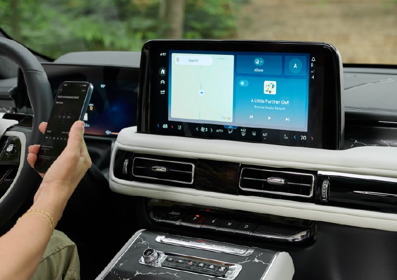 A person pairs thier phone with the center touchscreen of a 2027 Lincoln Aviator® Black Label™ SUV | LaFontaine Lincoln Grand Blanc in Flint MI