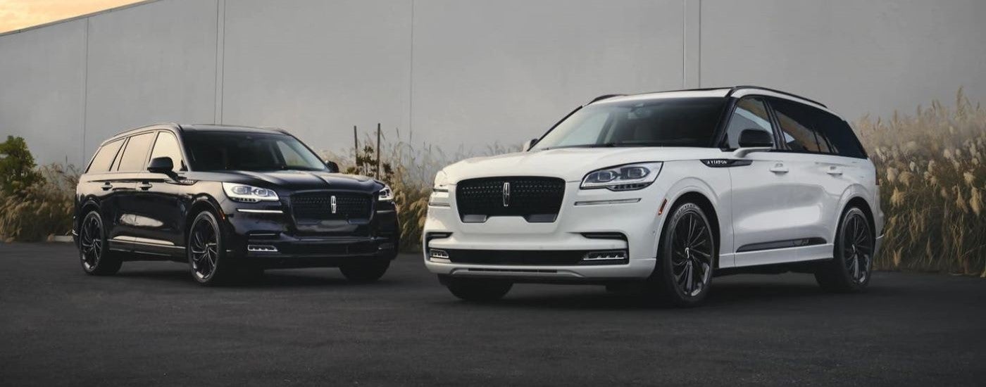 A black and a white 2023 Lincoln Aviator & Black Label Special Edition Luxe parked