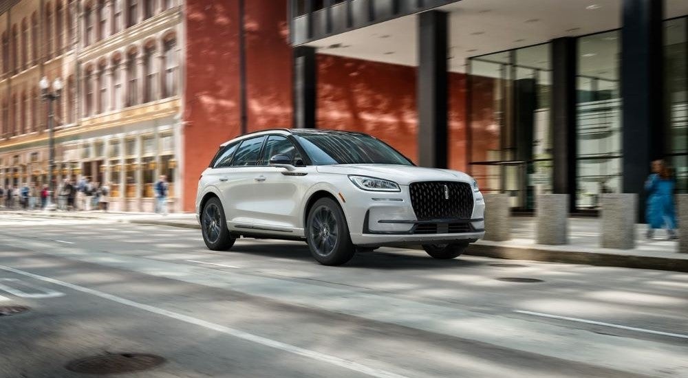 White 2023 Lincoln Corsair driving in the city.