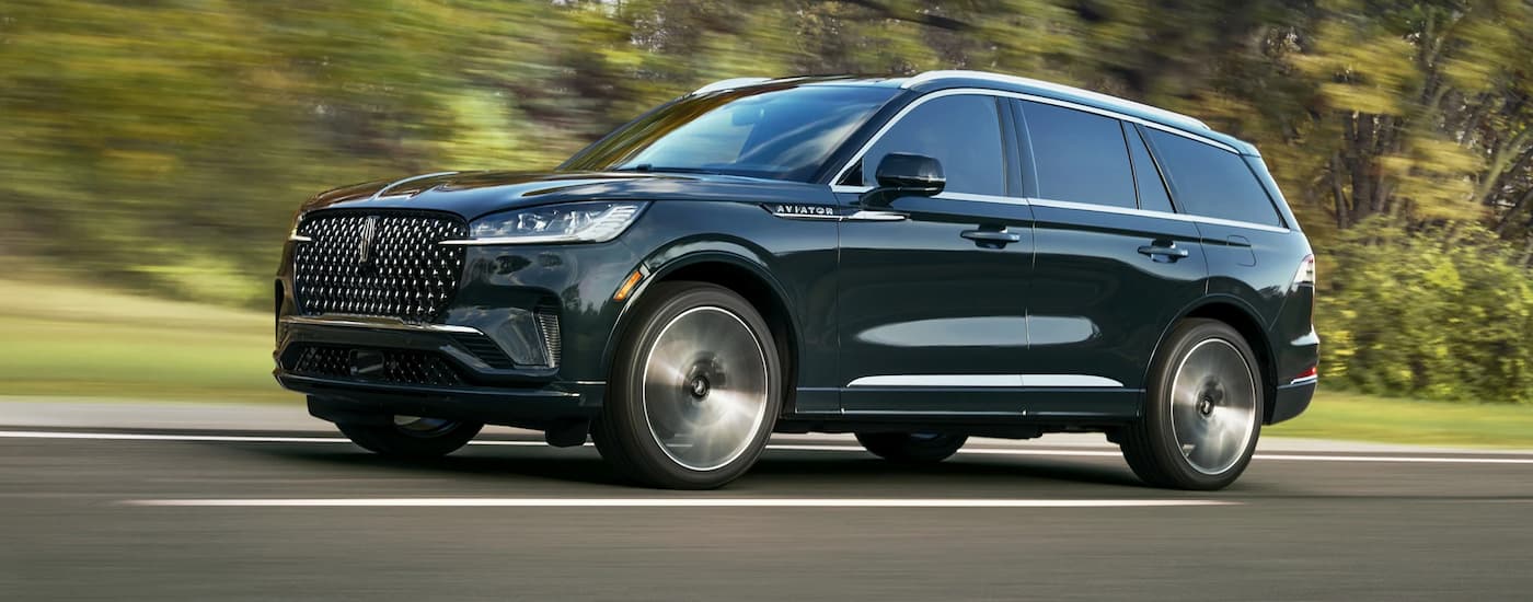 Green 2025 Lincoln Aviator driving on a highway