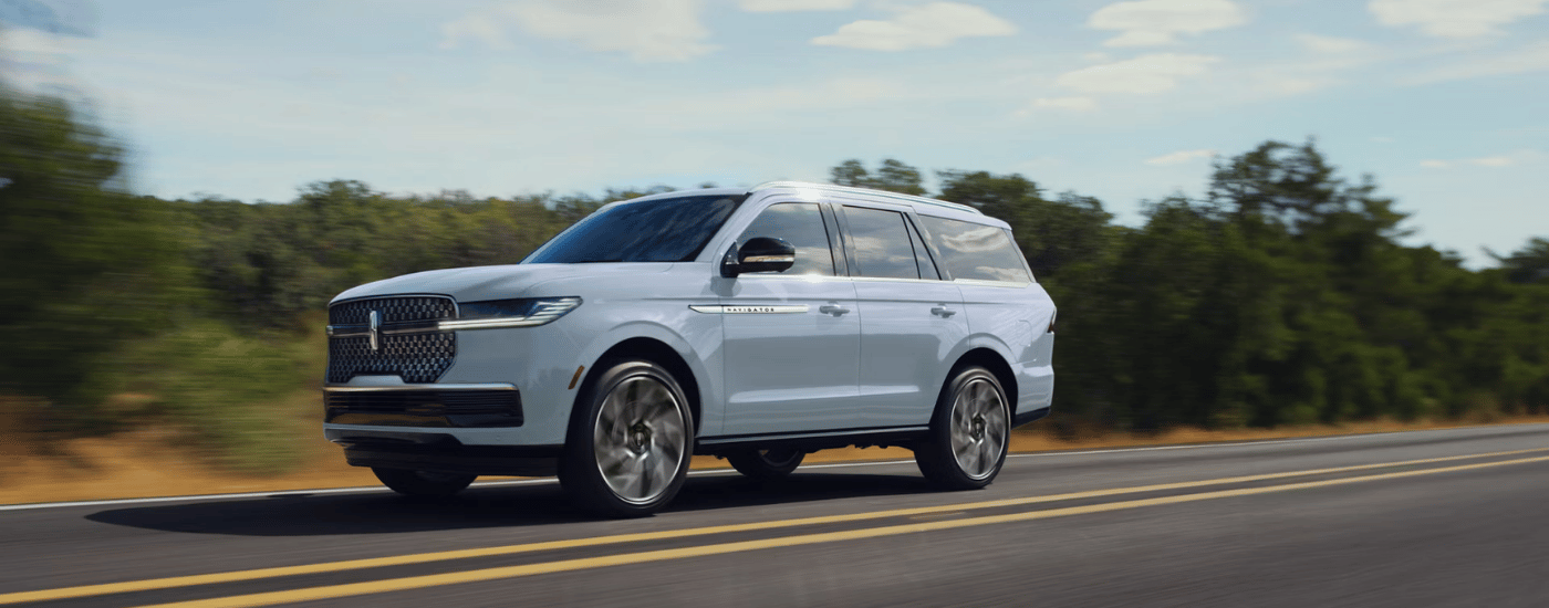 Blue 2027 Lincoln Navigator driving down an open road