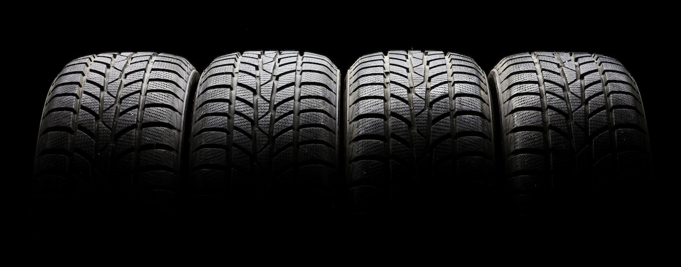 Row of tires on a black background.