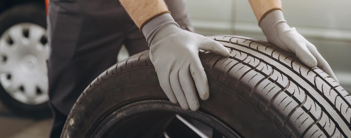 Close-up of a mechanic rolling a tire.