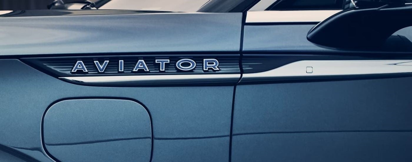 Close-up on the badge of a blue 2023 Lincoln Aviator PHEV.